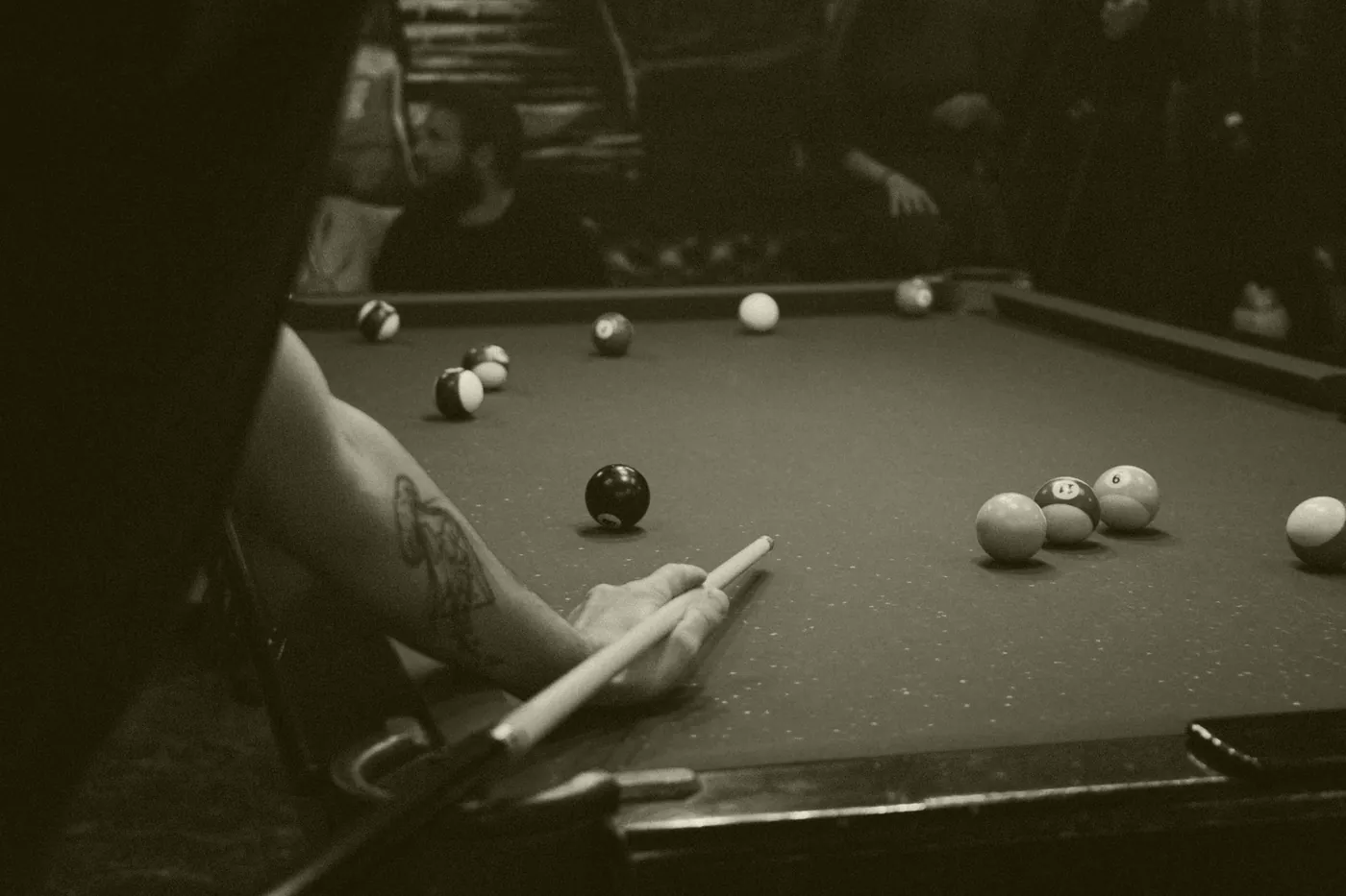 Pessoa jogando sinuca em mesa de feltro